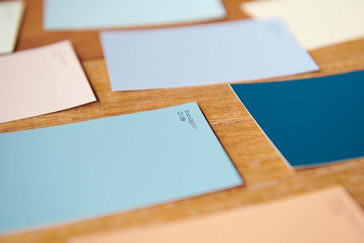 Muestras de color neutral y azul en una superficie de madera.