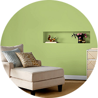 Bright green wall with inset nook and white trim, neutral extended upholstered chair.