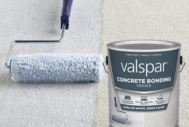 Rodillo que aplica Valspar Concrete Bonding Primer gris azulado claro a superficie de concreto. Lata en el primer plano.