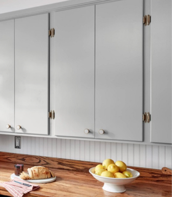 Los gabinetes de la cocina Granite Dust arriba de encimera de madera con hogaza de pan y tazón de limones.