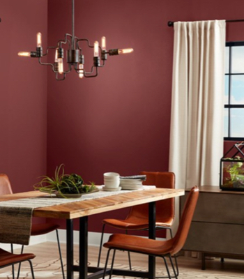 Comedor romántico y moderno Red henna con mobiliario de cuero, madera y metal y ventanas de paneles oscuros.