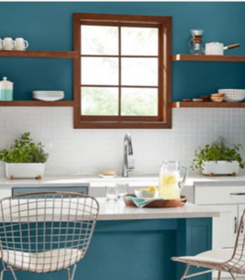 Cocina con encimera Sky Space y pared, gabinetes blancos, mostrador gris y molduras blancas y estantes.