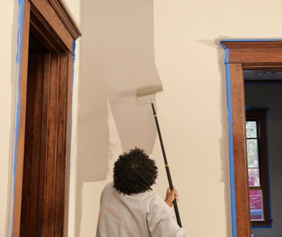persona pintando una pared con un rodillo