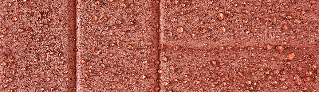 Ladrillos rojos con gotas de lluvia que se forman en la parte superior.